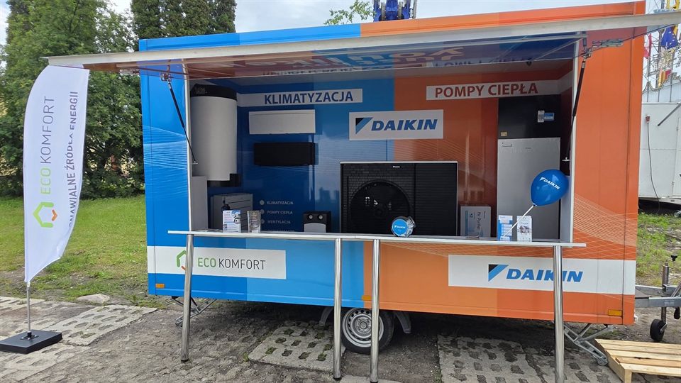 Przyczepa wystawowa Daikin w kolorach niebieskim i pomarańczowym z otwartą ścianą boczną i ekspozycją urządzeń